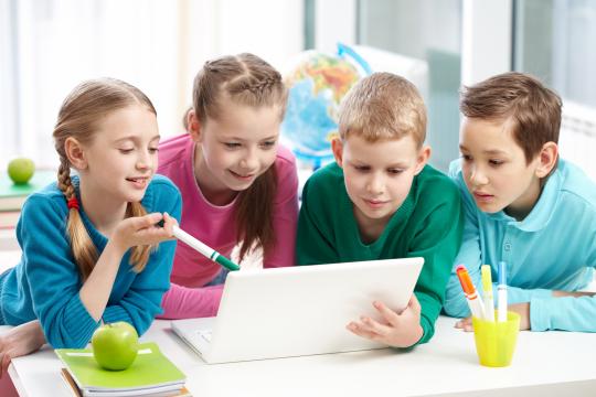 Kinder beim gemeinsamen Lernen mit einem Laptop.